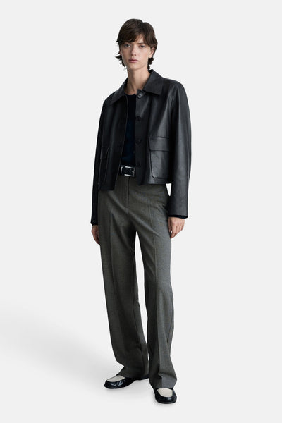 Grijze broek met rechte pijpen van MANGO, gedragen met een zwart leren jasje en tweekleurige platte schoenen.