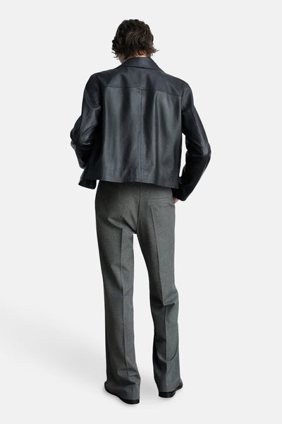Grijze pantalon met rechte pijpen van MANGO, gedragen met een zwart leren jasje en zwarte platte schoenen.