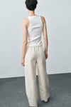 Witte tanktop van MANGO, in geribbelde stof, gedragen met een crèmekleurige broek met elastische taille.