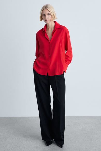 Chemisier rouge à manches longues de MANGO, porté avec un pantalon noir ample.
