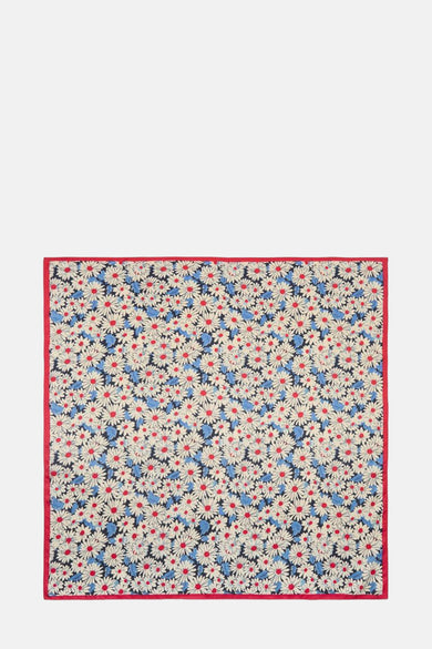 Rode sjaal van MANGO, met madeliefjespatroon en blauwe bladeren op een marineblauwe achtergrond, rode rand.