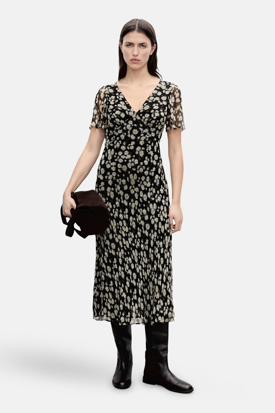 Robe noire à fleurs de MANGO, portée avec des bottes hautes et un sac marron.
