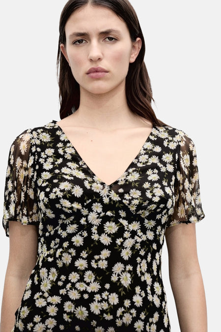 Zwarte jurk met korte mouwen van MANGO, bedrukt met witte madeliefjesbloemenpatronen over de hele oppervlakte.