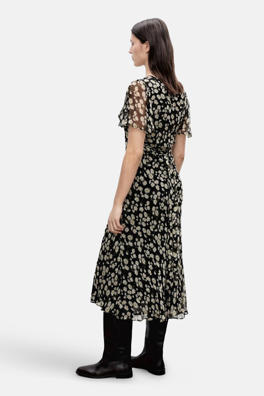 Robe noire à fleurs de MANGO, avec des manches courtes et des bottes en cuir noir.