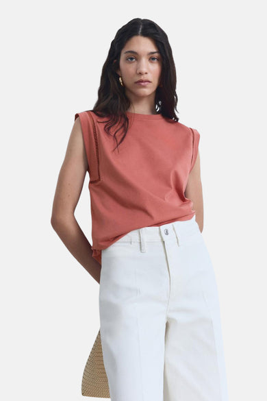 Mouwloze top van MANGO met uitgesneden details op de schouders, gedragen met een wijde witte broek.