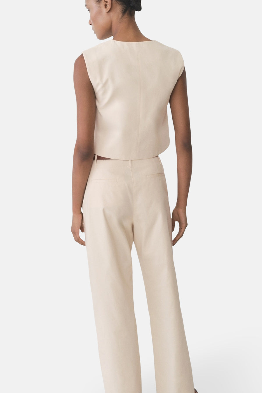 Pantalon écru de MANGO, coupe ample, avec poches arrière, porté avec un haut coordonné.