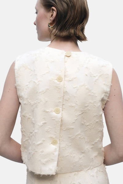 Ecru mouwloos blouse van MANGO, met reliëftextuur en knoopsluiting aan de achterkant.