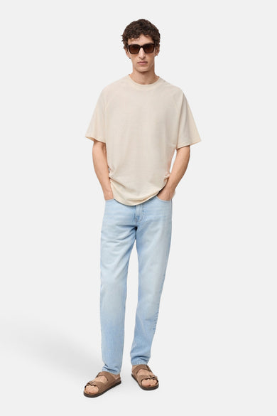 Ecru T-shirt met korte mouwen van MANGO, gedragen met een lichtblauwe jeans en bruine sandalen.