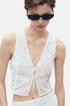 Blouse blanche sans manches de MANGO, en broderie anglaise avec une fermeture à nouer.