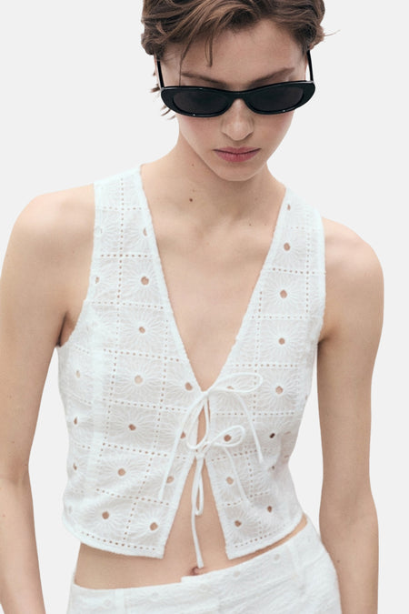 Wit mouwloos bloesje van MANGO, met broderie anglaise details en striklinten.