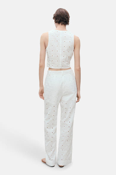 Blouse blanche sans manches de MANGO avec motif ajouré et pantalon assorti.