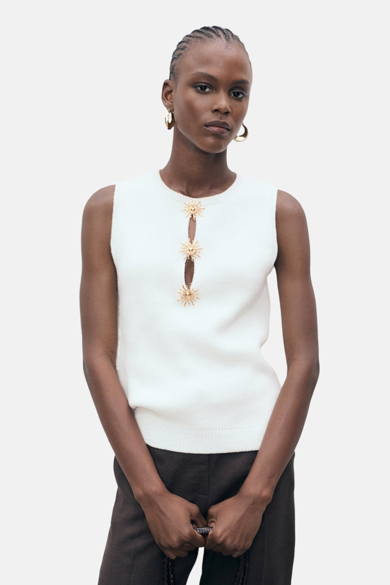 Wit mouwloos overhemd van MANGO, versierd met drie zonvormige decoraties.
