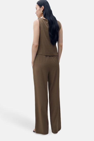 Bruine broek van MANGO, met elastische taille en wijde pijpen, gedragen met een bijpassend topje.