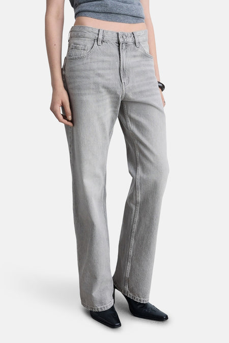 Jean droit gris moyen de MANGO, porté avec un haut court, et des chaussures noires à talons.