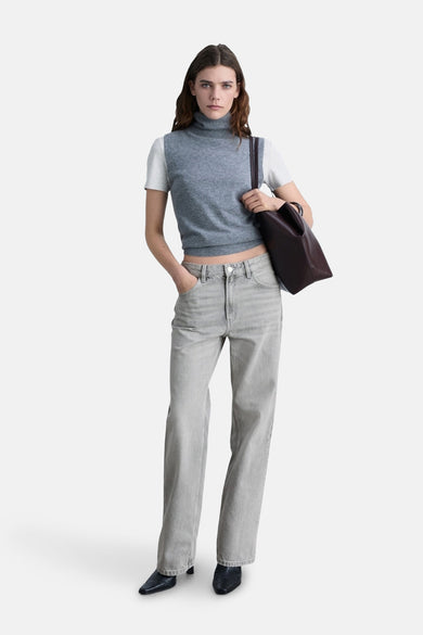 Middengrijze rechte jeans van MANGO, gedragen met een grijze mouwloze trui en een bruine handtas.