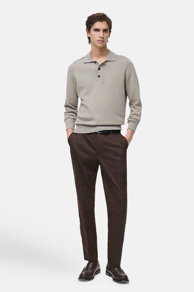 Pantalon cargo brun de MANGO, porté avec une ceinture noire, un polo en maille gris et des mocassins en cuir.