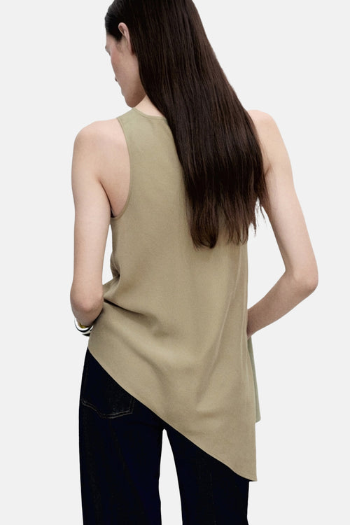 Blouse kaki sans manches de MANGO, portée avec un jean bleu foncé.