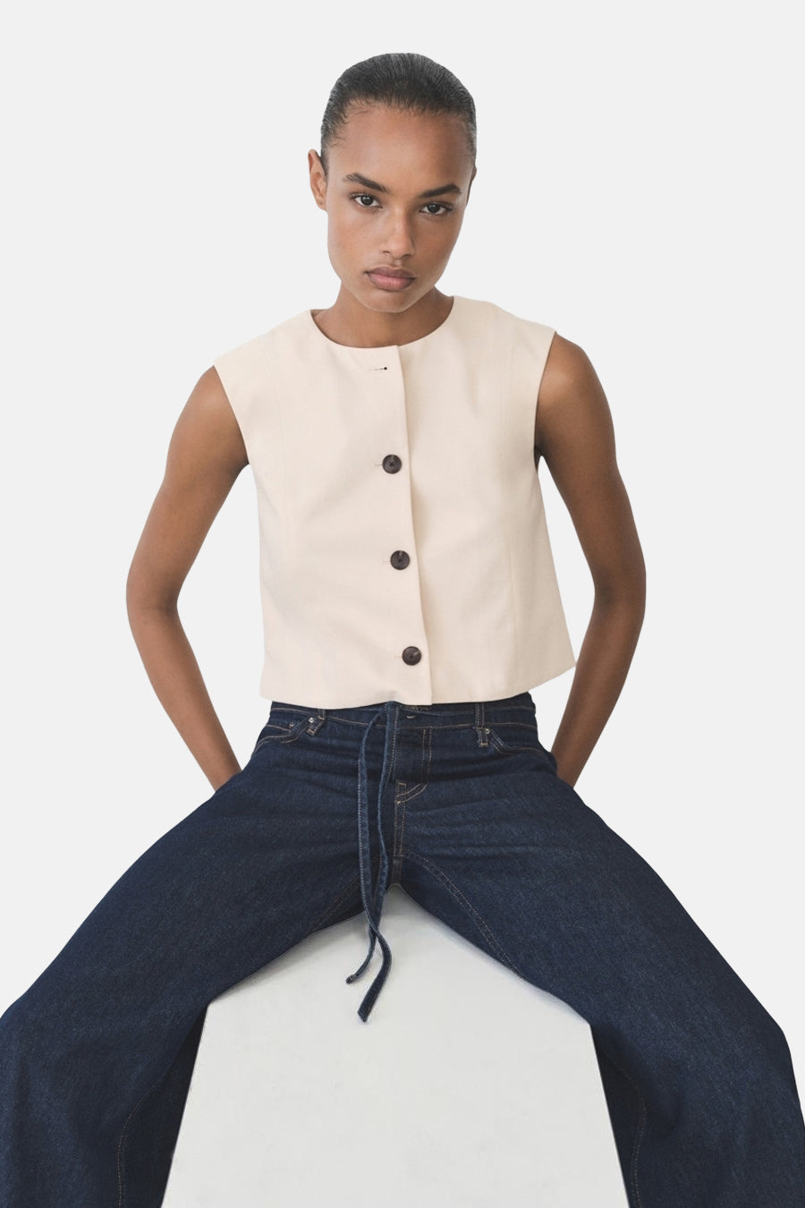 Blazer écru de MANGO, avec fermeture boutonnée et porté avec un jean taille basse.