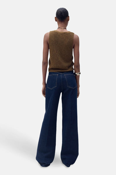 Débardeur brun de MANGO, porté avec un jean évasé bleu marine et un bracelet doré.