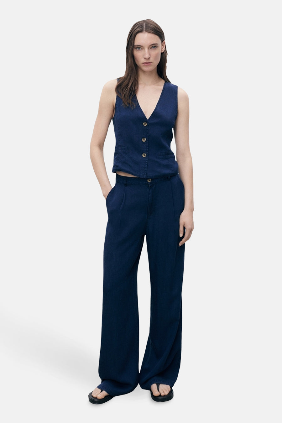 Donkerblauwe spijkerblazer van MANGO, gedragen met een bijpassende wijde broek en zwarte sandalen.