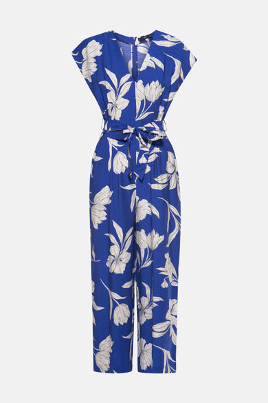 Blauwe jumpsuit van MANGO, met wit bloemenpatroon, met een strikceintuur in de taille.