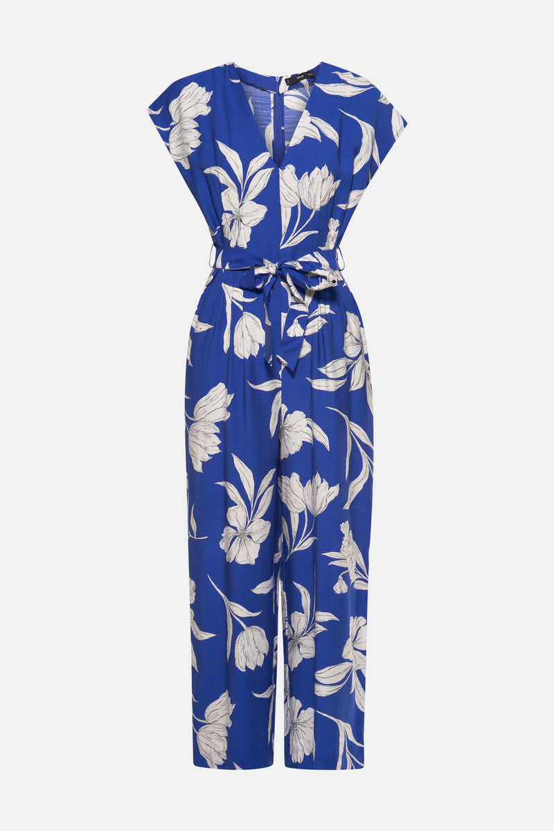 Blauwe jumpsuit van MANGO, met wit bloemenpatroon, met een strikceintuur in de taille.