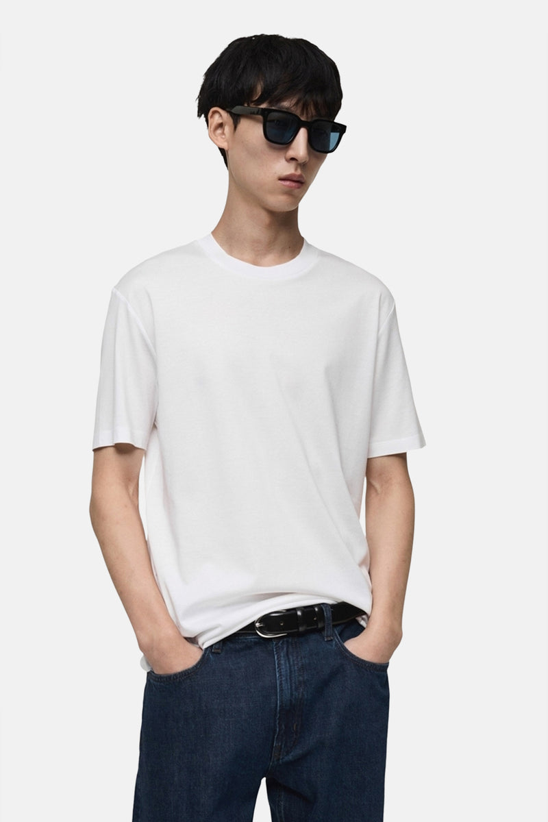 Wit T-shirt met korte mouwen van MANGO, model van achteren gezien gedragen met een blauwe jeans.