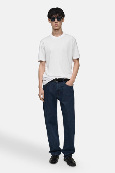 Wit T-shirt met korte mouwen van MANGO, gedragen met een donkerblauwe jeans en zwarte schoenen.
