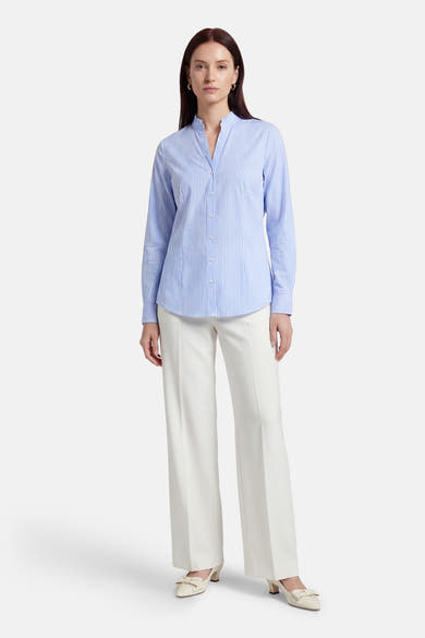 Blauw gestreept overhemd met lange mouwen van MORE & MORE, gedragen met een witte broek met hoge taille en hakken.