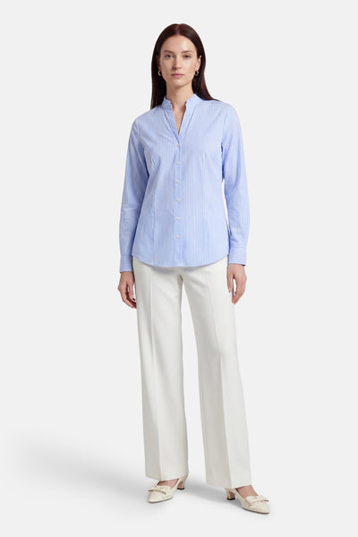 Blauw gestreept overhemd met lange mouwen van MORE & MORE, gedragen met een witte broek met hoge taille en hakken.