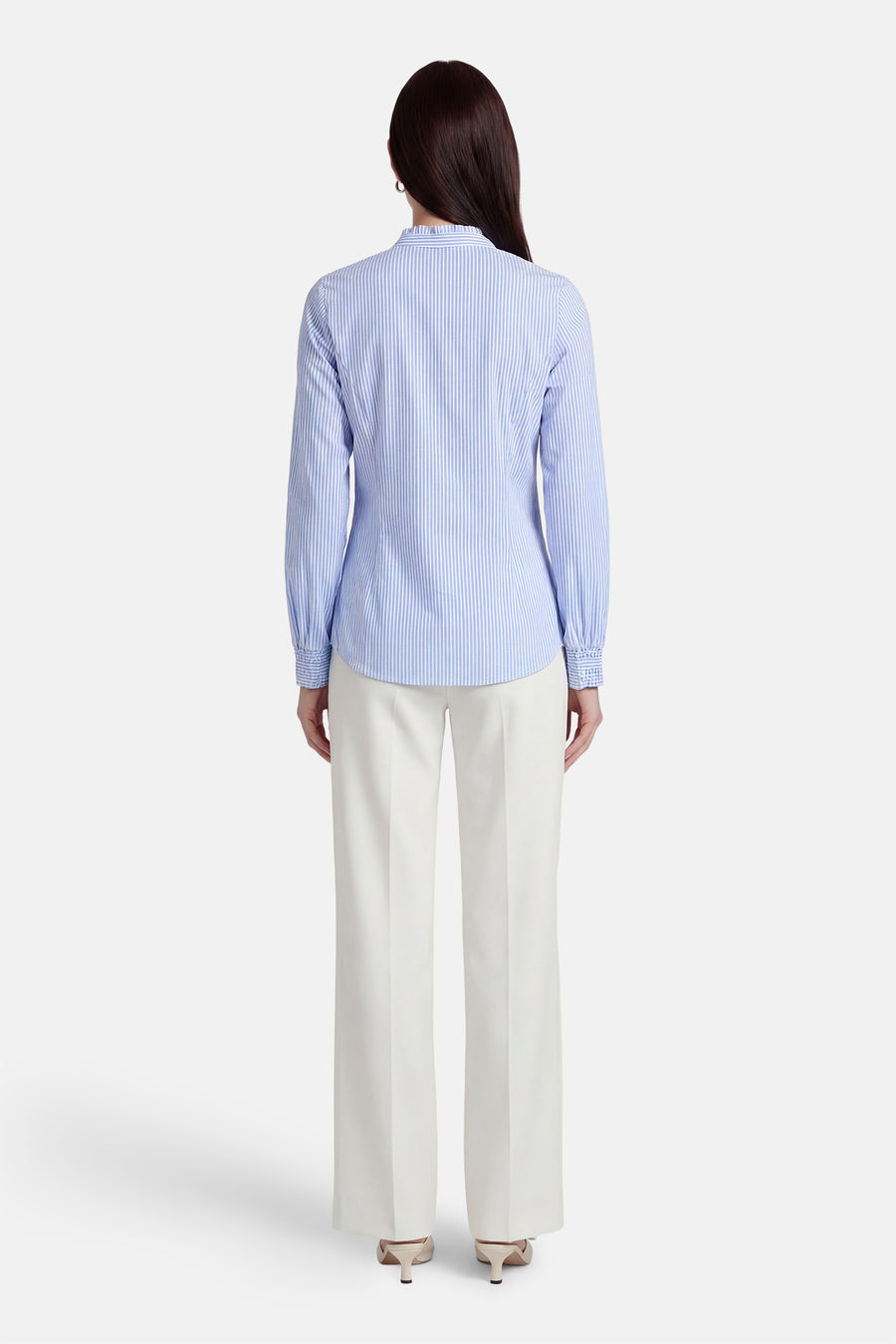 Chemise à manches longues bleue rayée de MORE & MORE, portée avec un pantalon blanc à jambes larges.