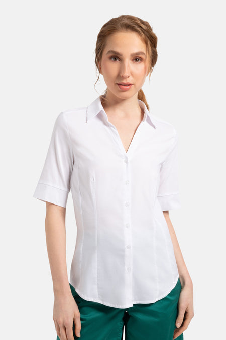 Wit 3/4-blouse van MORE & MORE, gedragen met een smaragdgroene short en crèmekleurige sneakers.