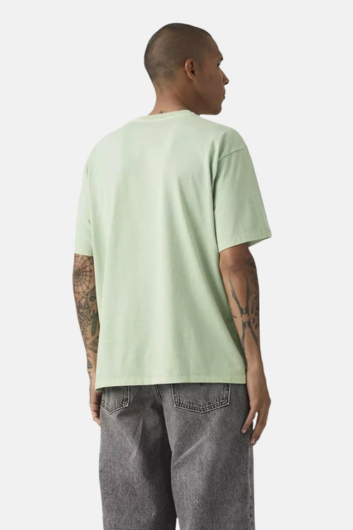 T-shirt vert à manches courtes par Levi's®, porté avec un pantalon gris délavé, vue de dos.
