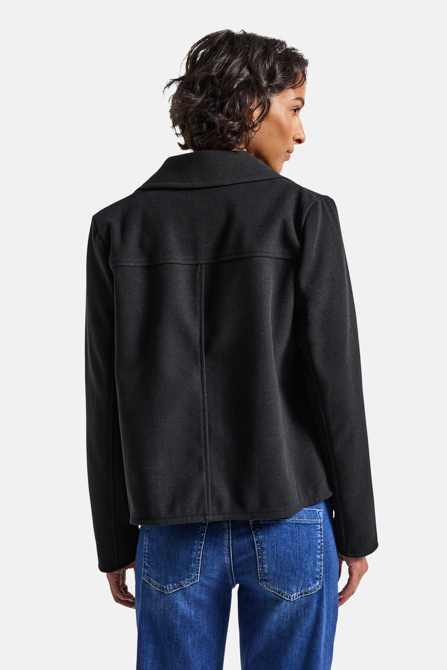 Kort marineblauw jasje van STREET ONE, vierkante pasvorm, met reverskraag en opgestikte zakken op de rug, gedragen met een blauwe jeans.