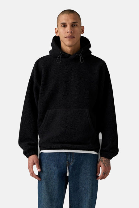 Zwarte hoodie van fleece van Levi's, met trekkoord, gedragen met een blauwe jeans.