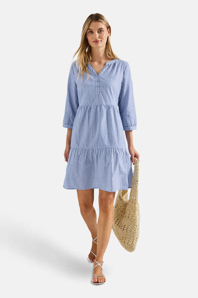 Blauw-wit gestreepte jurk van STREET ONE, met een relaxte pasvorm en een rieten tas in de hand.