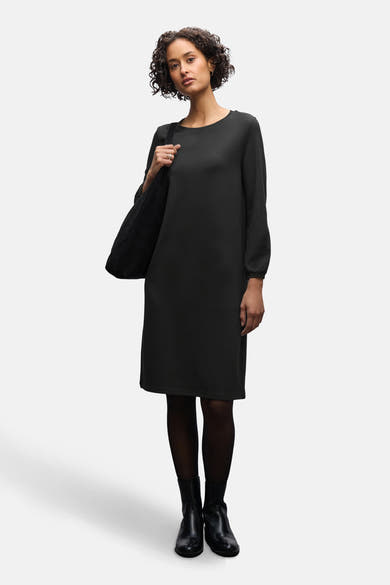 Robe noire de STREET ONE, portée avec des collants noirs et des bottines en cuir noir.
