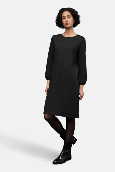 Robe noire de STREET ONE, portée avec des collants noirs et des bottines en cuir noir.