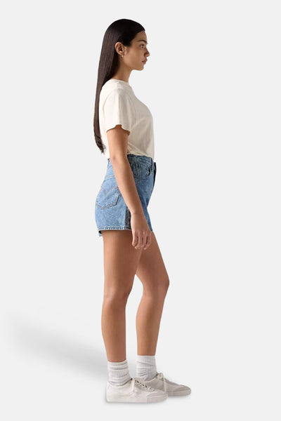 Short en denim délavé de Levi's®, porté avec un t-shirt blanc et des baskets blanches.