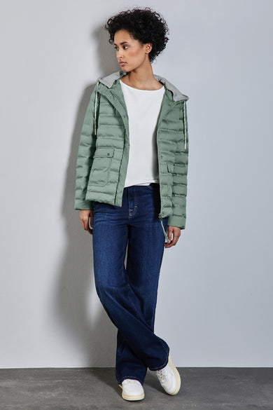 Veste courte verte de Street One, avec capuche grise, portée avec un t-shirt blanc et un jean bleu.