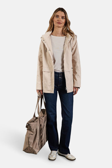 Beige regenjas van Street One met capuchon en zakken, gedragen met een spijkerbroek en een bruine handtas.