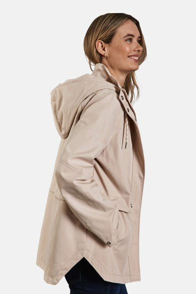 Beige regenjas van STREET ONE, met capuchon en handen in de zakken, zijaanzicht.