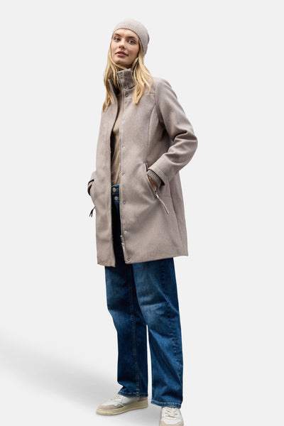 Veste longue brune par STREET ONE, portée avec un bonnet en tricot et un jean bleu ample.