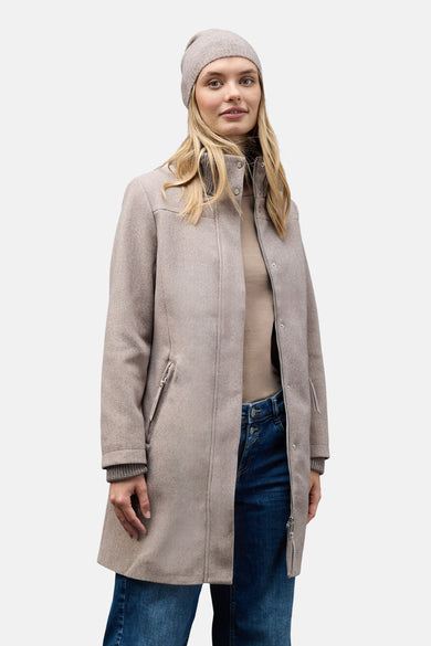 Lange bruine jas van Street One met ritssluiting, gedragen met een muts en een blauwe jeans.