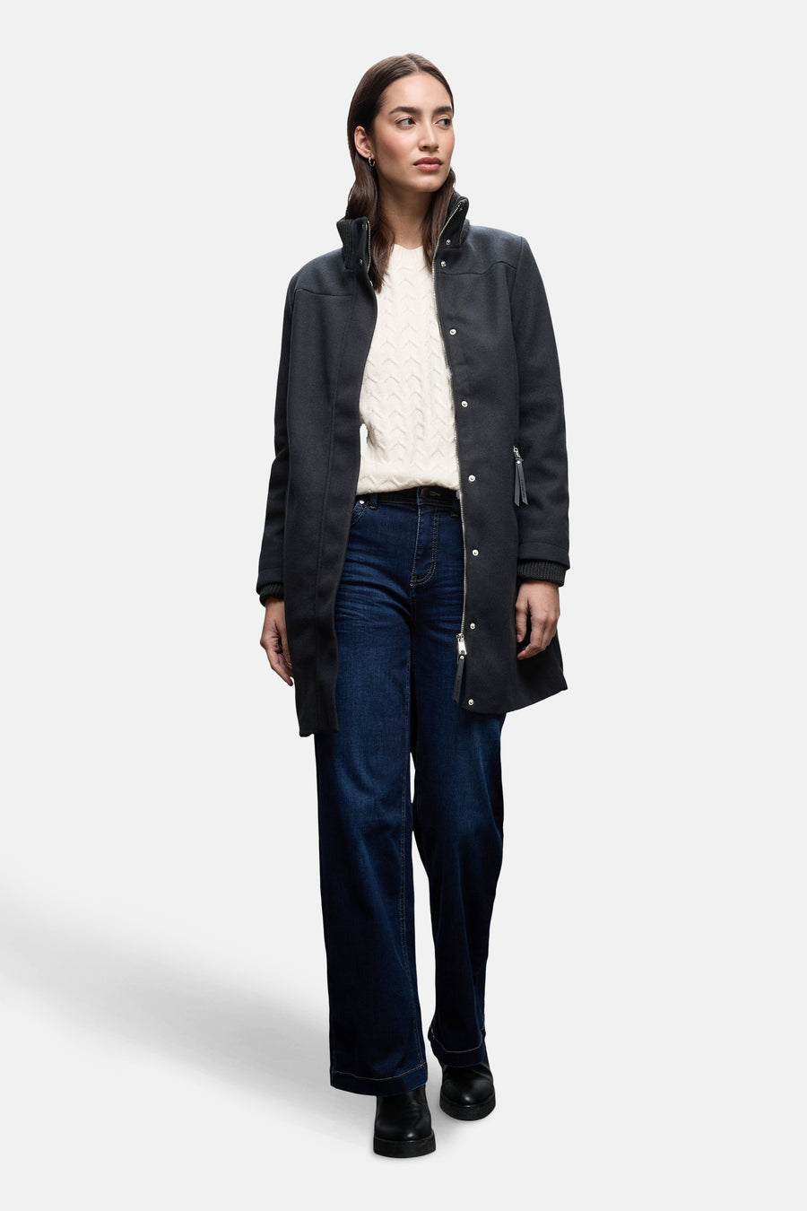 Lange blauwe jas van STREET ONE, met zilveren ritssluiting en gedragen met een witte kabeltrui.