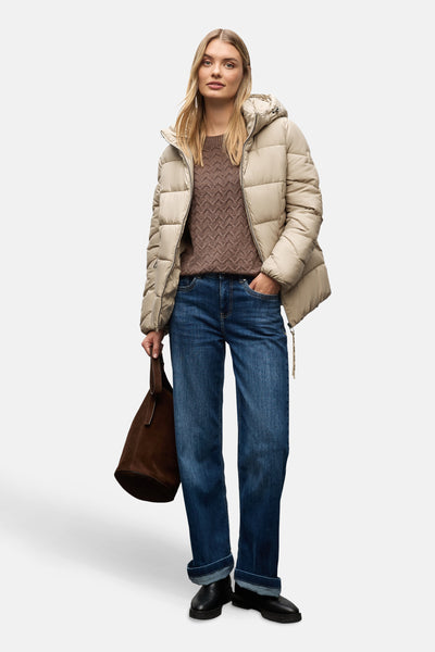 Kort beige jasje van STREET ONE, gedragen met een bruine trui, een blauwe jeans en zwarte enkellaarsjes.