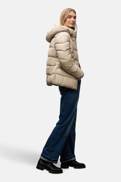 Veste courte beige de Street One, portée avec un jean évasé bleu et des bottines noires.
