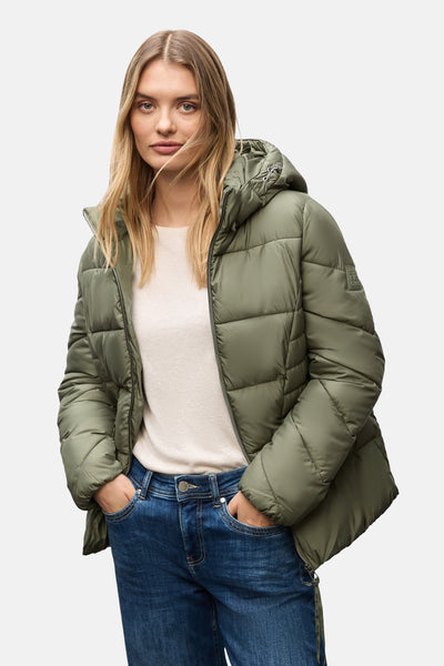 Veste courte verte de Street One, avec capuche et poches avant, portée sur un pull clair et un jean.