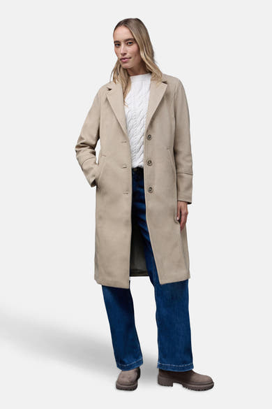 Lange beige jas van Street One, met zakken, gedragen met een witte trui en een blauwe jeans.