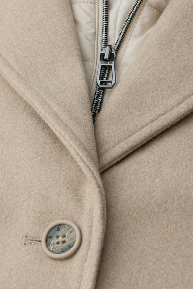 Lange beige jas van STREET ONE, met zilveren ritssluiting en knoop met logo-gravure.